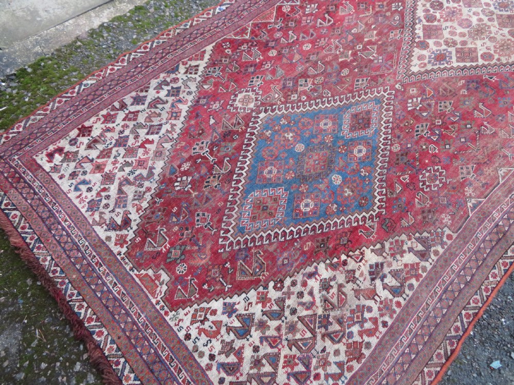 An antique hand-knotted Khamseh tribal kelleh carpet with a dark red field, geometric diamond medallions, and small bird motifs. View XX