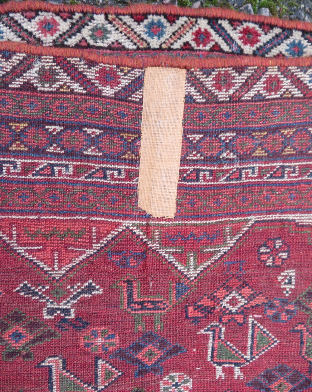 An antique hand-knotted Khamseh tribal kelleh carpet with a dark red field, geometric diamond medallions, and small bird motifs. View XXII