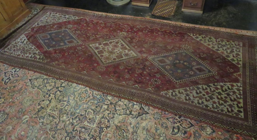An antique hand-knotted Khamseh tribal kelleh carpet with a dark red field, geometric diamond medallions, and small bird motifs. View XXV