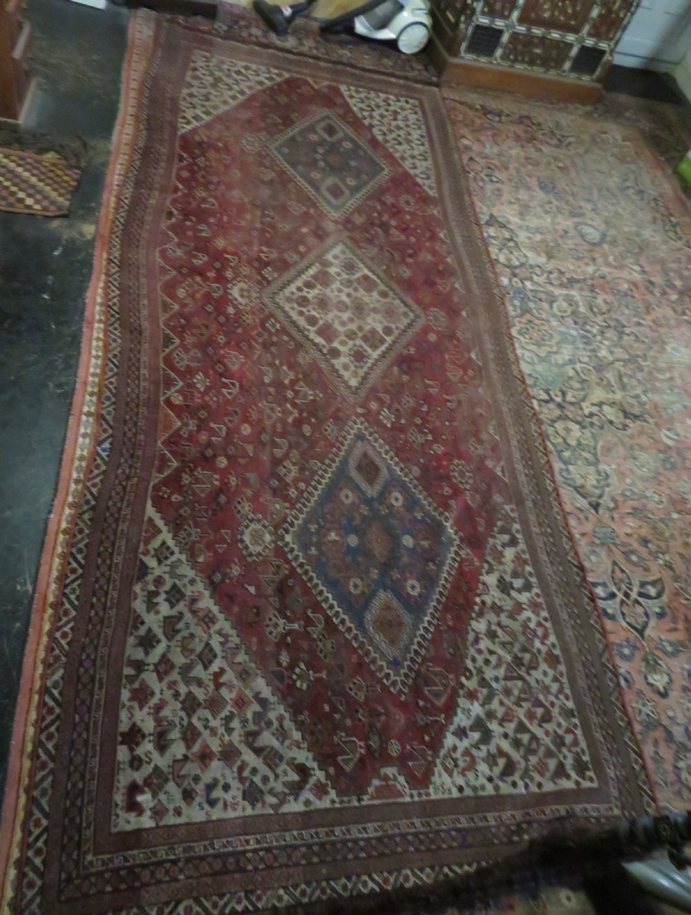An antique hand-knotted Khamseh tribal kelleh carpet with a dark red field, geometric diamond medallions, and small bird motifs. View XXVI