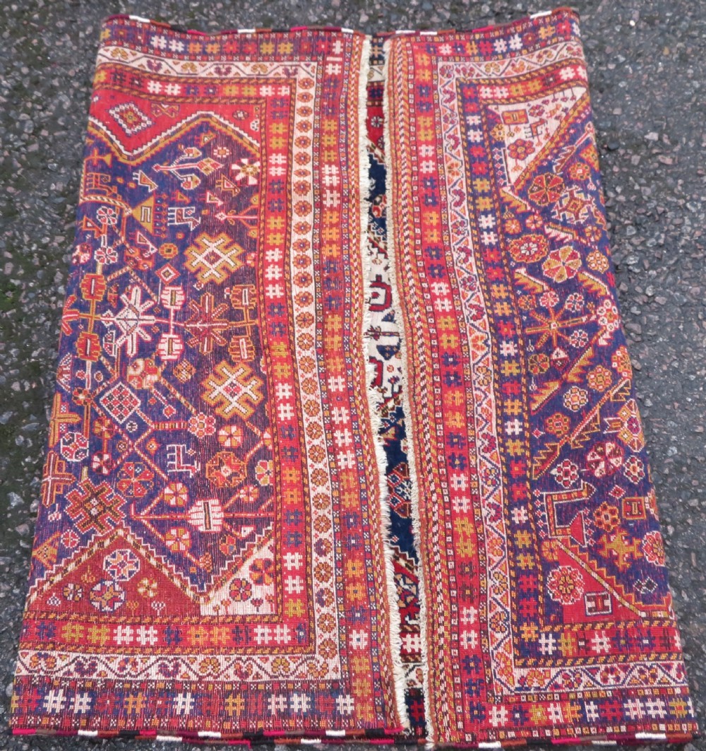 An antique hand-knotted Qashqai wool rug featuring a central ivory diamond medallion surrounded by detailed geometric and animal motifs on a navy blue field with a red border. View XIII