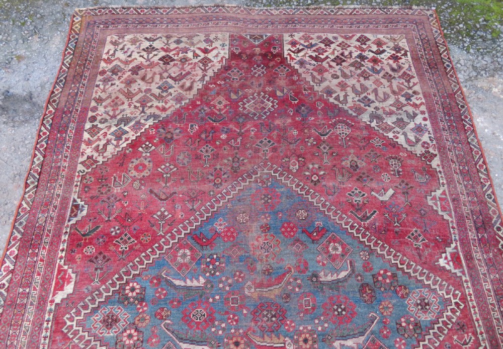 A long hand-knotted antique Persian Khamseh carpet featuring geometric diamond medallions and intricate tribal motifs in red, blue, and cream tones. View III