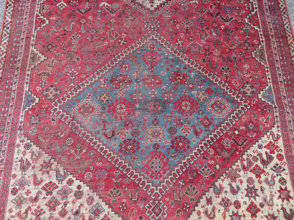 A long hand-knotted antique Persian Khamseh carpet featuring geometric diamond medallions and intricate tribal motifs in red, blue, and cream tones. View V