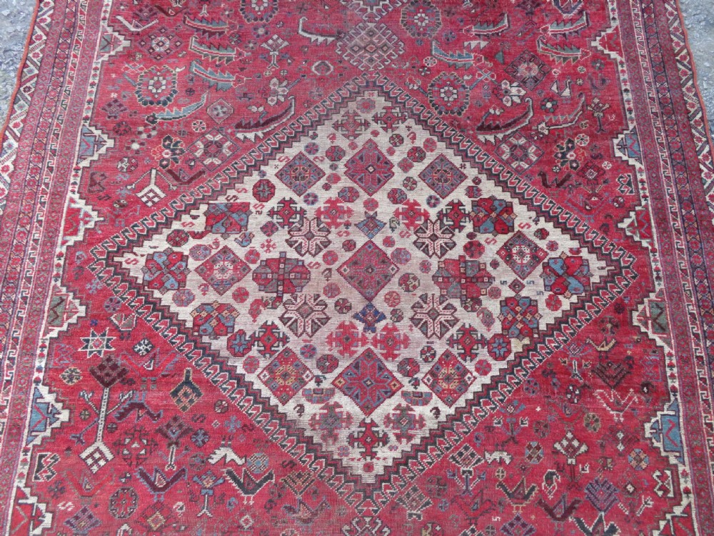 A long hand-knotted antique Persian Khamseh carpet featuring geometric diamond medallions and intricate tribal motifs in red, blue, and cream tones. View VI