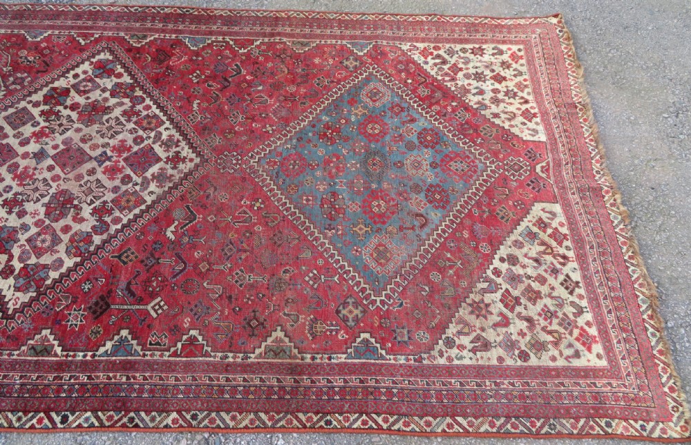 A long hand-knotted antique Persian Khamseh carpet featuring geometric diamond medallions and intricate tribal motifs in red, blue, and cream tones. View VII