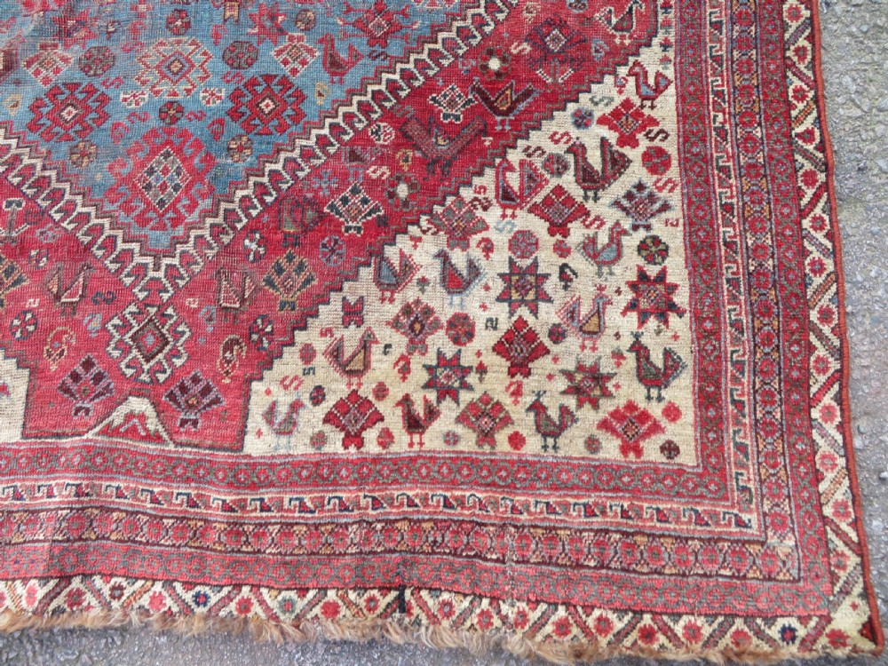 A long hand-knotted antique Persian Khamseh carpet featuring geometric diamond medallions and intricate tribal motifs in red, blue, and cream tones. View XI