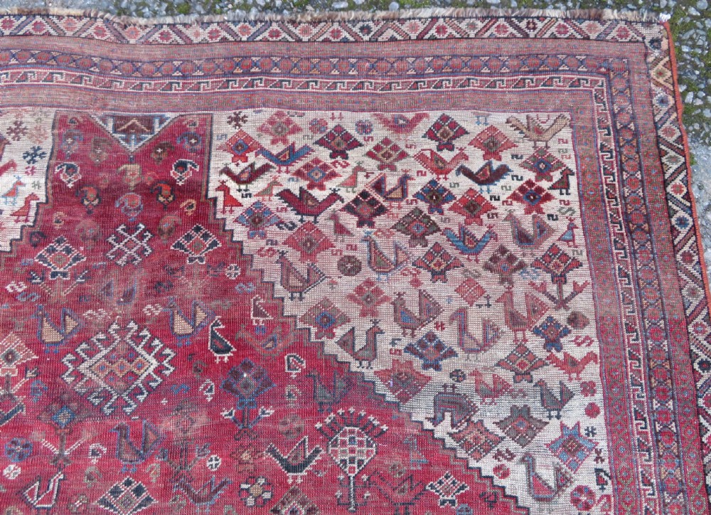A long hand-knotted antique Persian Khamseh carpet featuring geometric diamond medallions and intricate tribal motifs in red, blue, and cream tones. View XII