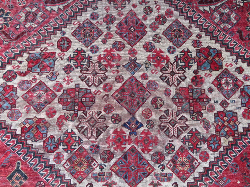 A long hand-knotted antique Persian Khamseh carpet featuring geometric diamond medallions and intricate tribal motifs in red, blue, and cream tones. View XV