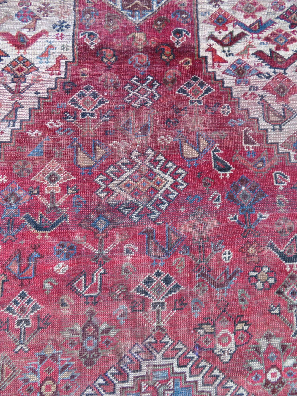 A long hand-knotted antique Persian Khamseh carpet featuring geometric diamond medallions and intricate tribal motifs in red, blue, and cream tones. View XVII