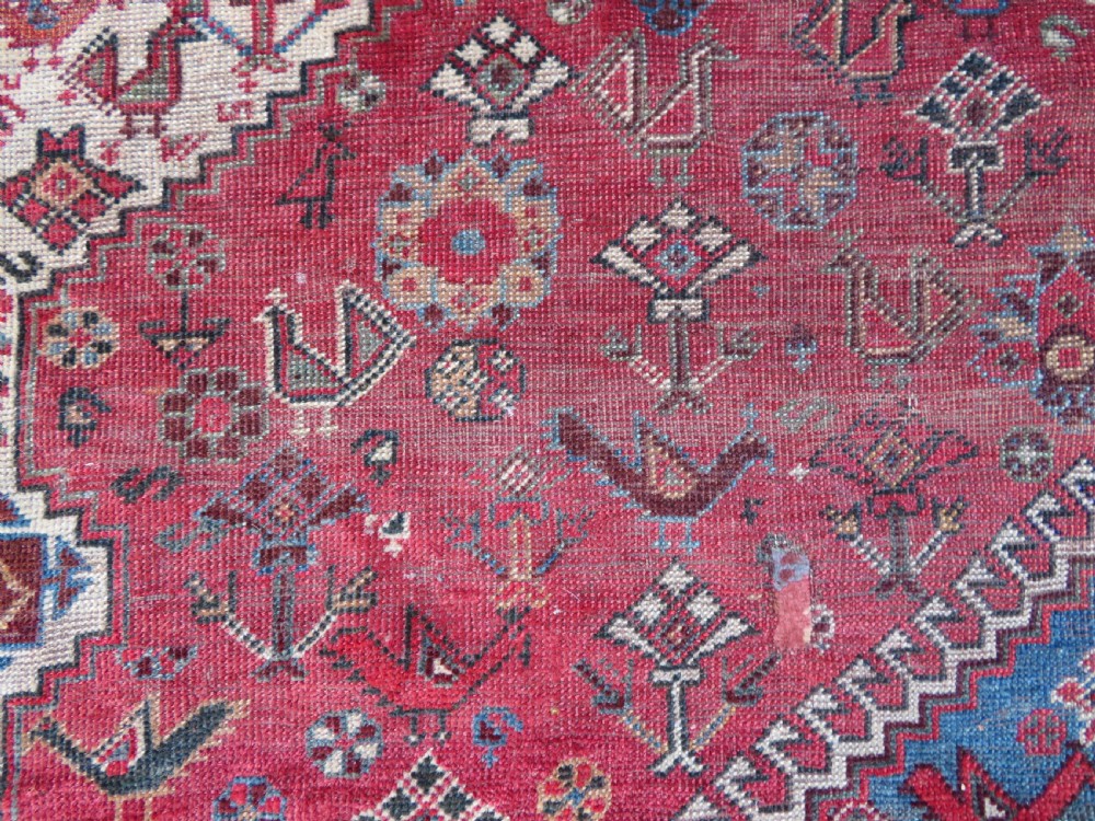 A long hand-knotted antique Persian Khamseh carpet featuring geometric diamond medallions and intricate tribal motifs in red, blue, and cream tones. View XVIII
