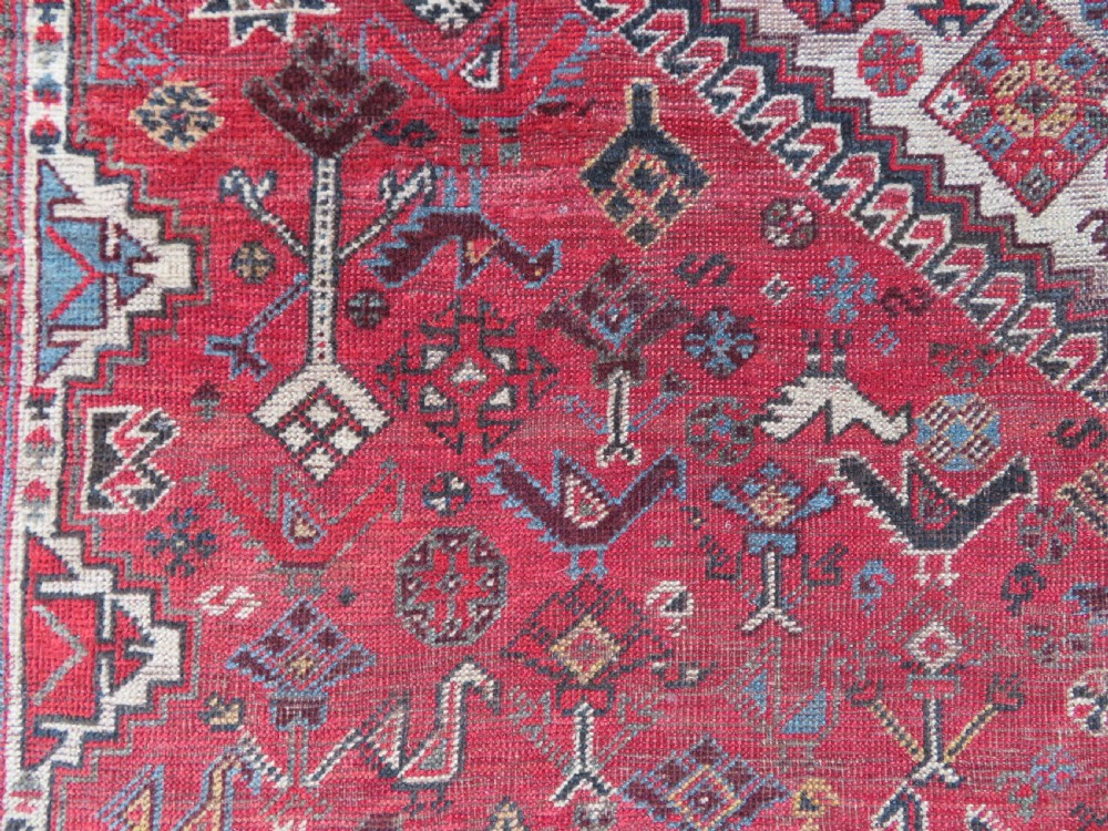 A long hand-knotted antique Persian Khamseh carpet featuring geometric diamond medallions and intricate tribal motifs in red, blue, and cream tones. View XXI