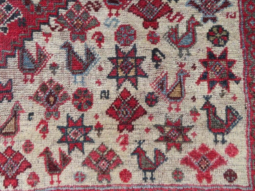 A long hand-knotted antique Persian Khamseh carpet featuring geometric diamond medallions and intricate tribal motifs in red, blue, and cream tones. View XXII