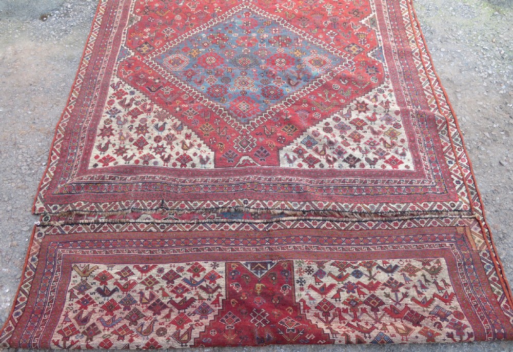 A long hand-knotted antique Persian Khamseh carpet featuring geometric diamond medallions and intricate tribal motifs in red, blue, and cream tones. View XXIV
