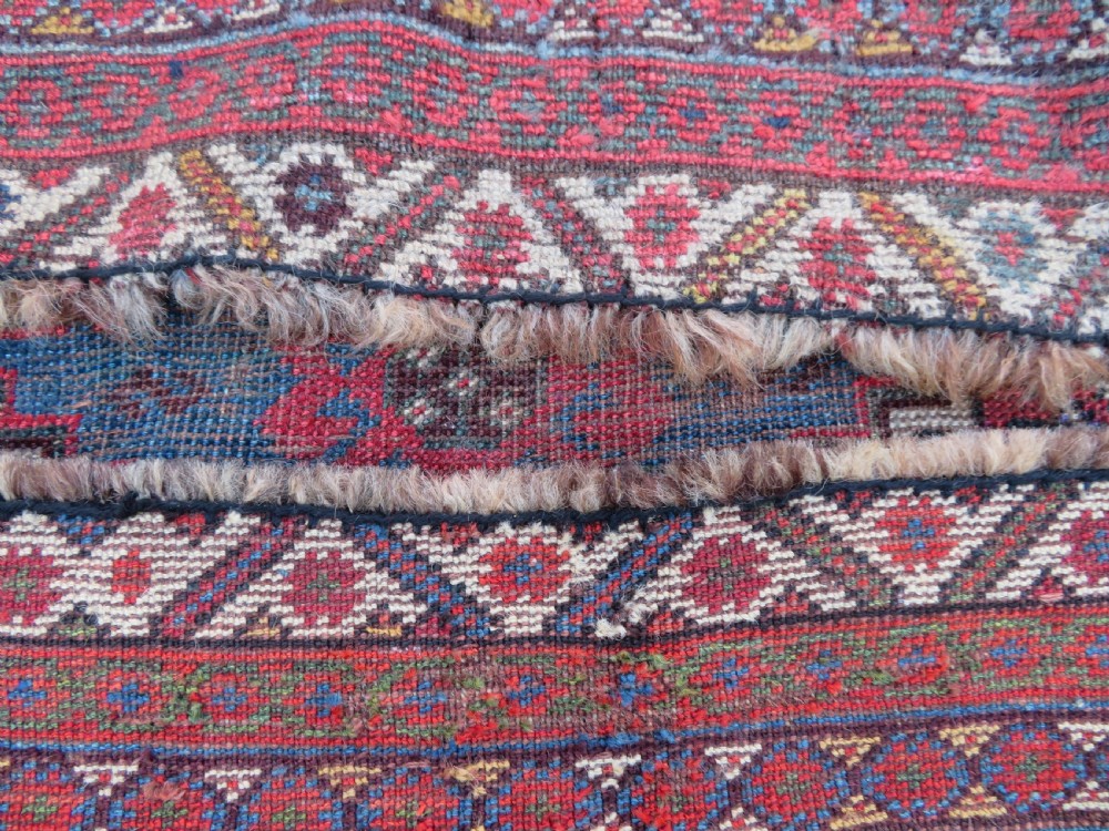 A long hand-knotted antique Persian Khamseh carpet featuring geometric diamond medallions and intricate tribal motifs in red, blue, and cream tones. View XXV