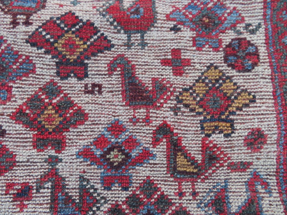 A long hand-knotted antique Persian Khamseh carpet featuring geometric diamond medallions and intricate tribal motifs in red, blue, and cream tones. View XXVI