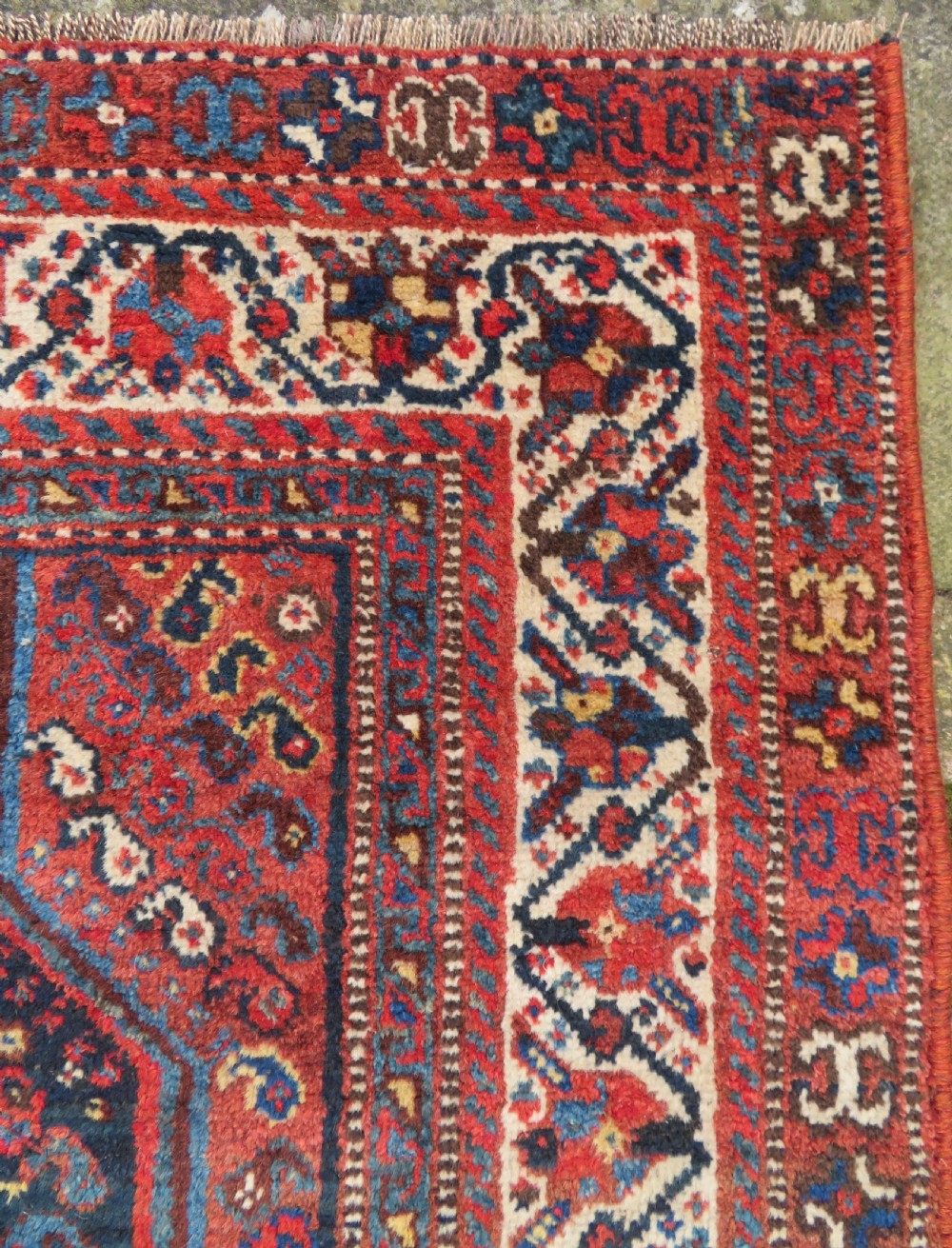 An antique Persian Qashqai hand-knotted wool rug with a dark navy blue field, double red geometric medallion, and multi-band patterned borders. View VIII