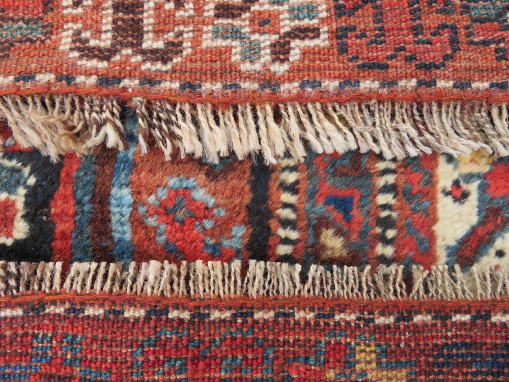 An antique Persian Qashqai hand-knotted wool rug with a dark navy blue field, double red geometric medallion, and multi-band patterned borders. View XIV