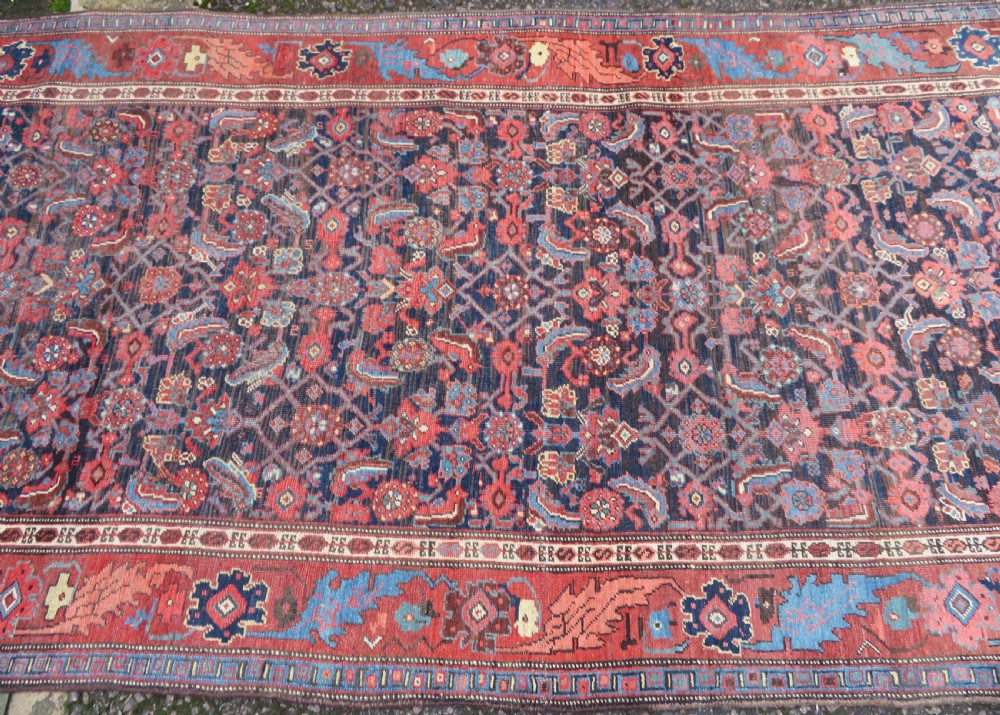 An antique Persian Bidjar Kelleh wool long rug featuring a central navy blue geometric botanical field surrounded by terracotta and blue borders. View V