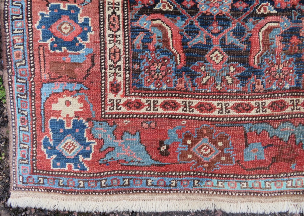 An antique Persian Bidjar Kelleh wool long rug featuring a central navy blue geometric botanical field surrounded by terracotta and blue borders. View VI