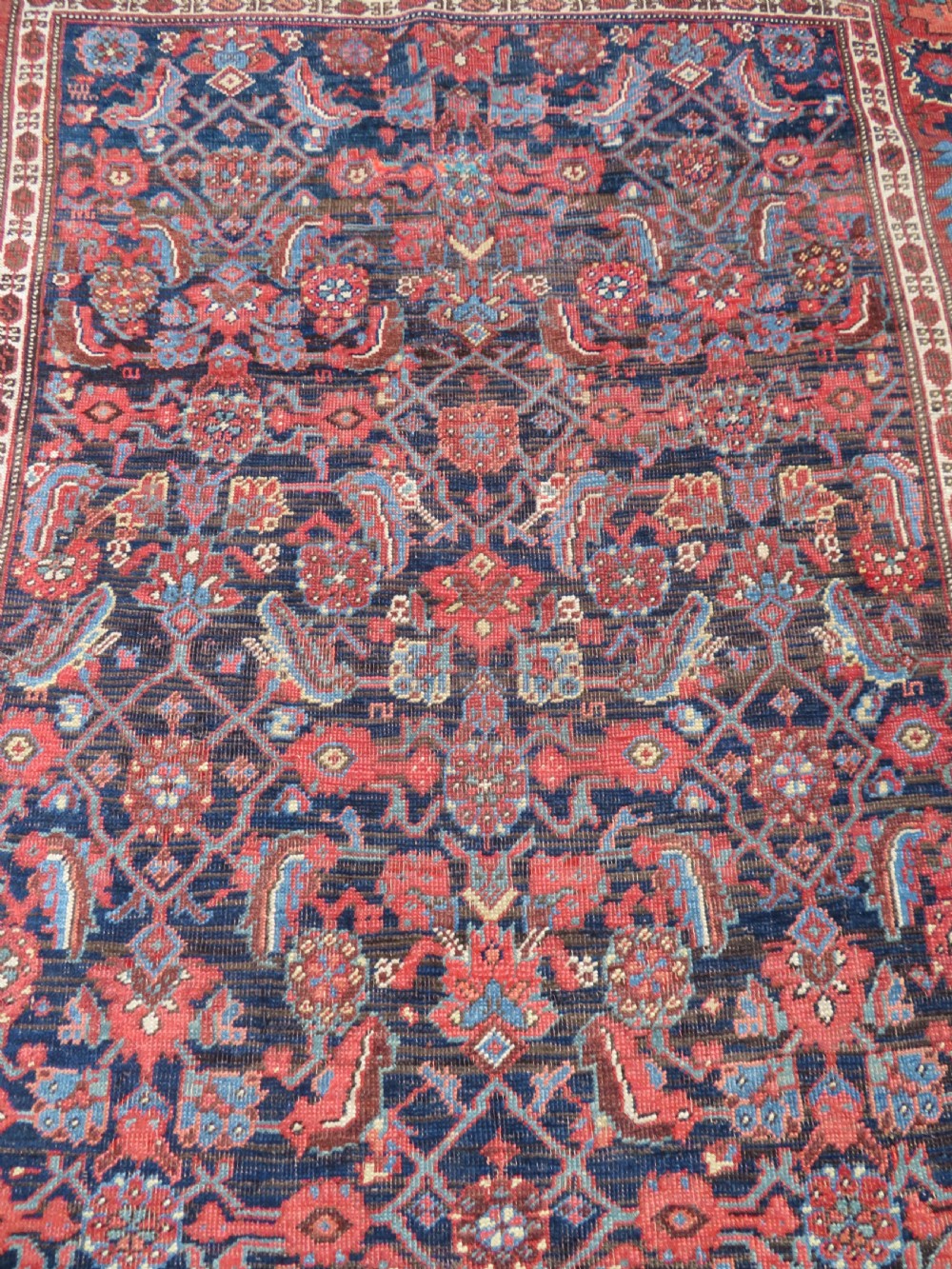 An antique Persian Bidjar Kelleh wool long rug featuring a central navy blue geometric botanical field surrounded by terracotta and blue borders. View VIII