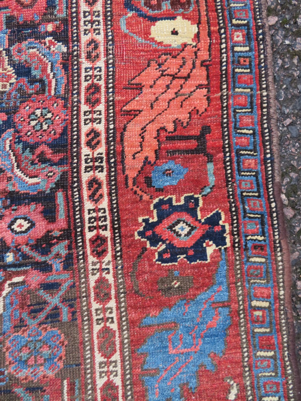 An antique Persian Bidjar Kelleh wool long rug featuring a central navy blue geometric botanical field surrounded by terracotta and blue borders. View X