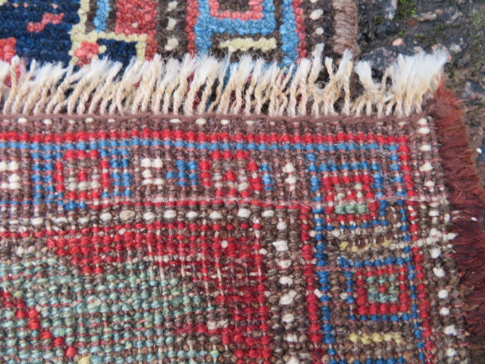 An antique Persian Bidjar Kelleh wool long rug featuring a central navy blue geometric botanical field surrounded by terracotta and blue borders. View XVI