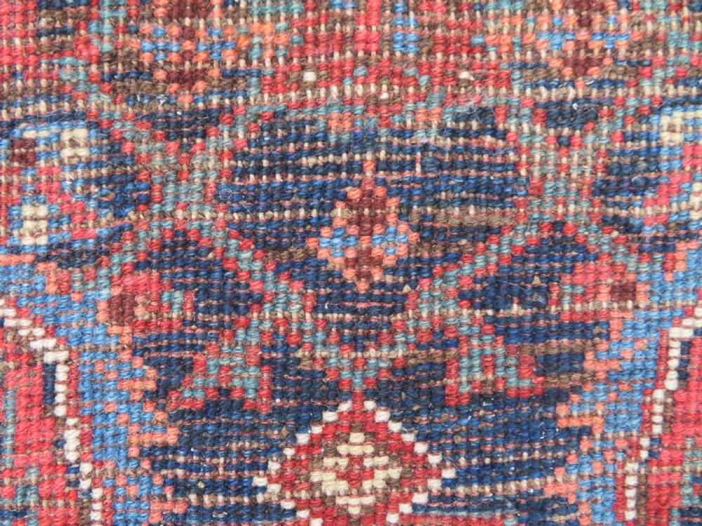 An antique Persian Bidjar Kelleh wool long rug featuring a central navy blue geometric botanical field surrounded by terracotta and blue borders. View XVII