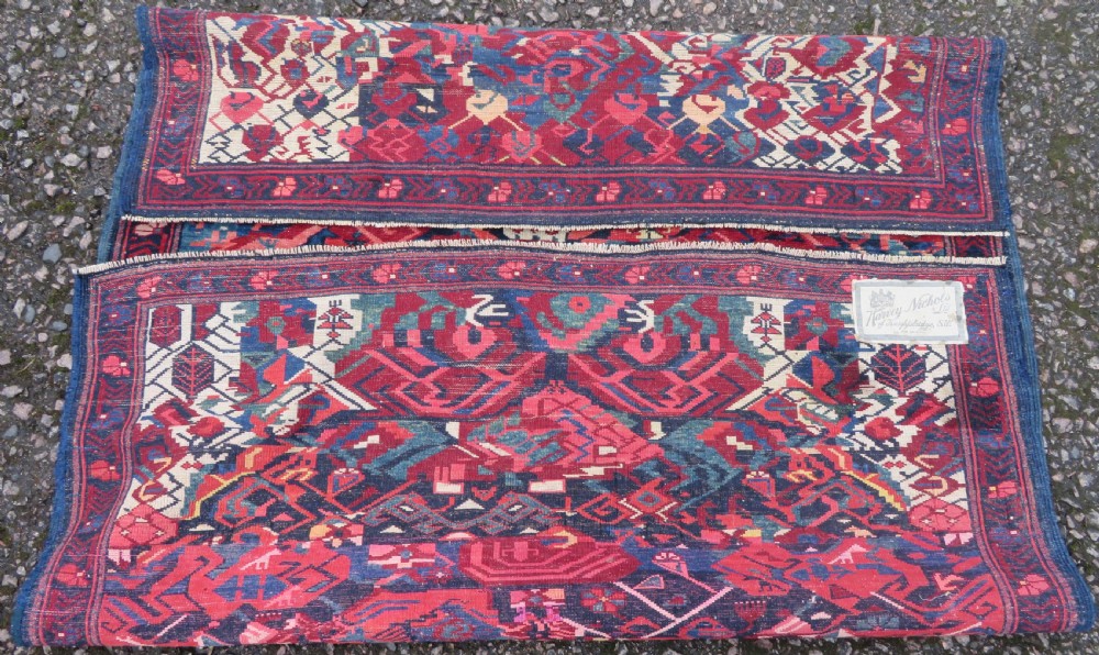 A rectangular hand-knotted antique Caucasian Kuba rug featuring complex geometric motifs in deep red, navy blue, light blue, and cream. View XVII
