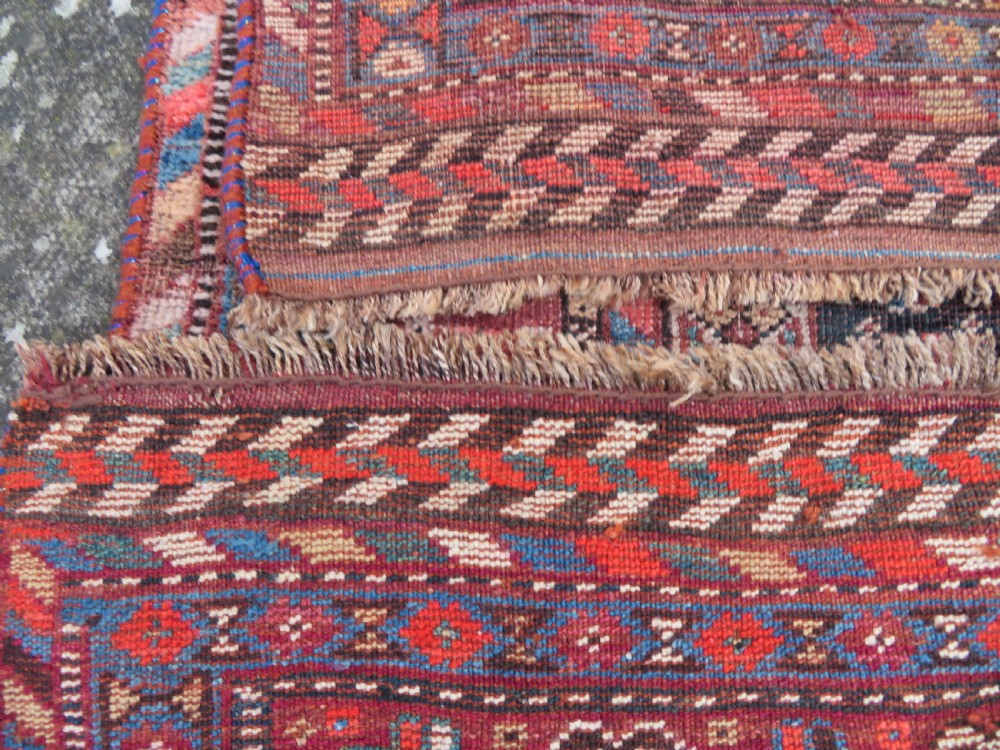 An antique Khamseh hand-knotted wool carpet featuring repeating stylised boteh motifs on a dark navy field with multi-banded geometric borders. View XXII