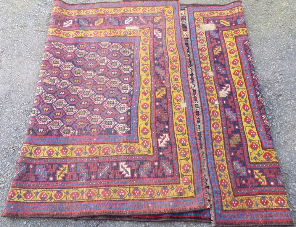 An antique hand-knotted Kurdish Kelleh long rug featuring a navy blue central field filled with repeating geometric motifs within multi-coloured yellow and red borders. View XIII