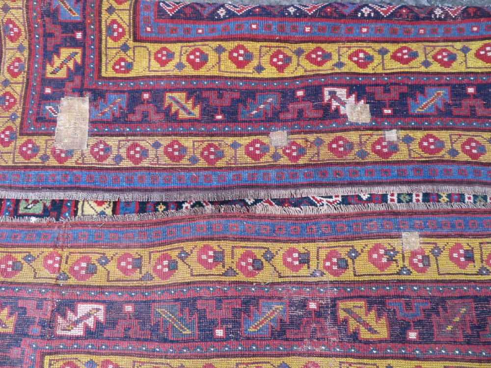 An antique hand-knotted Kurdish Kelleh long rug featuring a navy blue central field filled with repeating geometric motifs within multi-coloured yellow and red borders. View XV