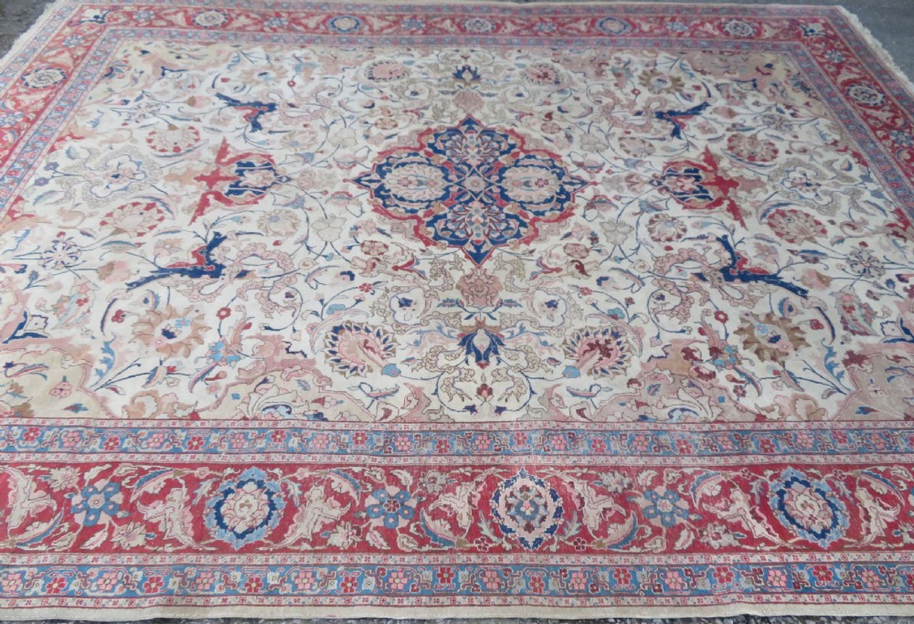 A large hand-knotted Persian Tabriz carpet featuring a central navy blue and red medallion on a cream field with floral vines and a prominent red border. View III
