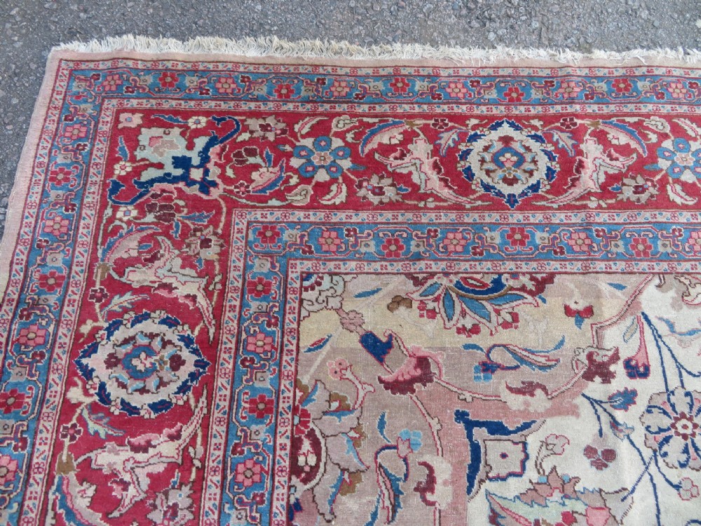 A large hand-knotted Persian Tabriz carpet featuring a central navy blue and red medallion on a cream field with floral vines and a prominent red border. View VIII