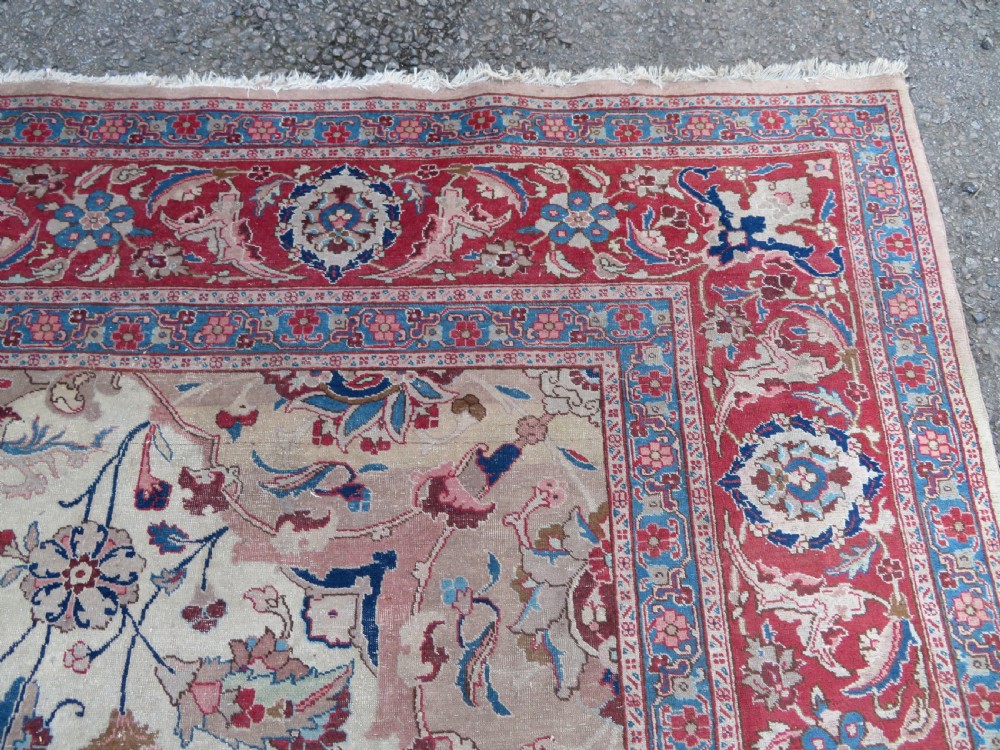 A large hand-knotted Persian Tabriz carpet featuring a central navy blue and red medallion on a cream field with floral vines and a prominent red border. View IX