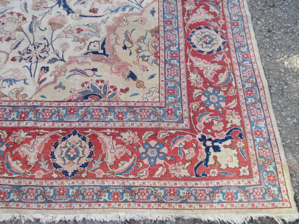 A large hand-knotted Persian Tabriz carpet featuring a central navy blue and red medallion on a cream field with floral vines and a prominent red border. View XI