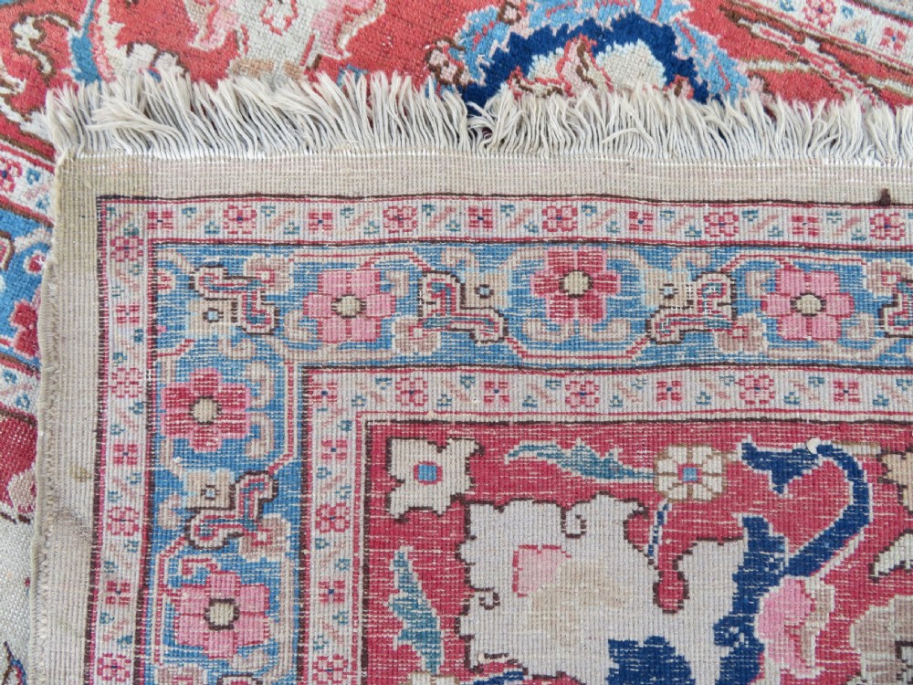 A large hand-knotted Persian Tabriz carpet featuring a central navy blue and red medallion on a cream field with floral vines and a prominent red border. View XVII