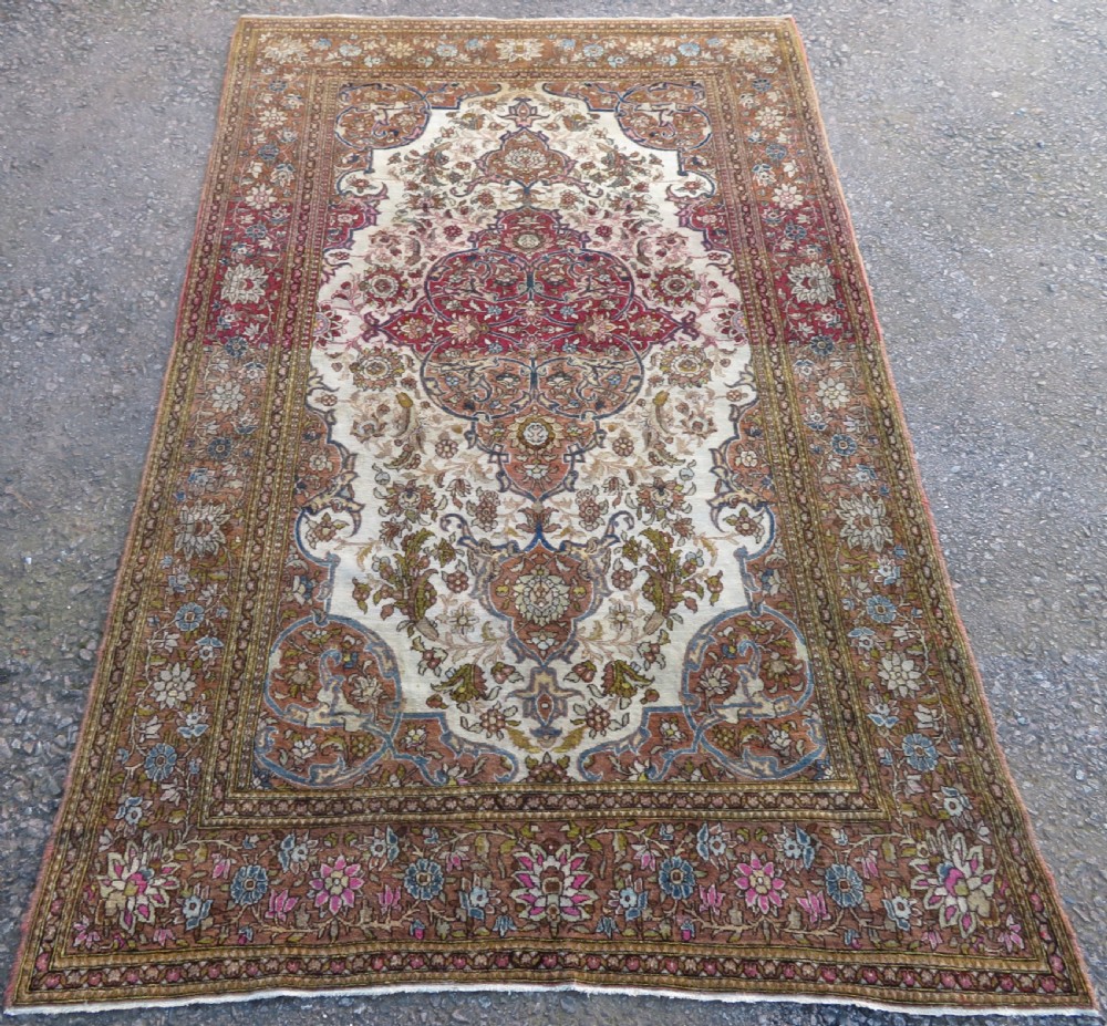 An antique hand-knotted Isfahan wool rug featuring a red central floral medallion on an ivory field surrounded by terracotta and blue floral borders. View II