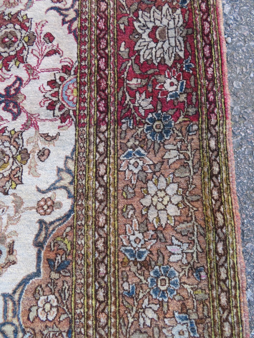 An antique hand-knotted Isfahan wool rug featuring a red central floral medallion on an ivory field surrounded by terracotta and blue floral borders. View VI