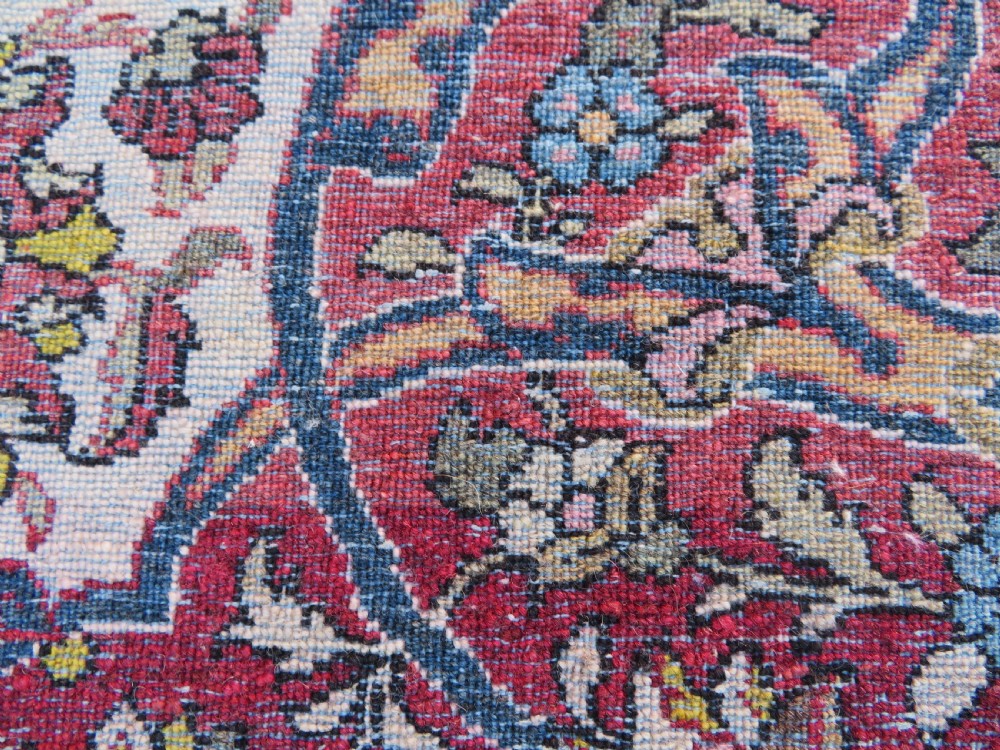 An antique hand-knotted Isfahan wool rug featuring a red central floral medallion on an ivory field surrounded by terracotta and blue floral borders. View XII
