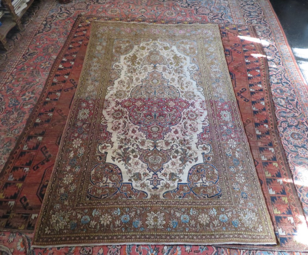 An antique hand-knotted Isfahan wool rug featuring a red central floral medallion on an ivory field surrounded by terracotta and blue floral borders. View XIII