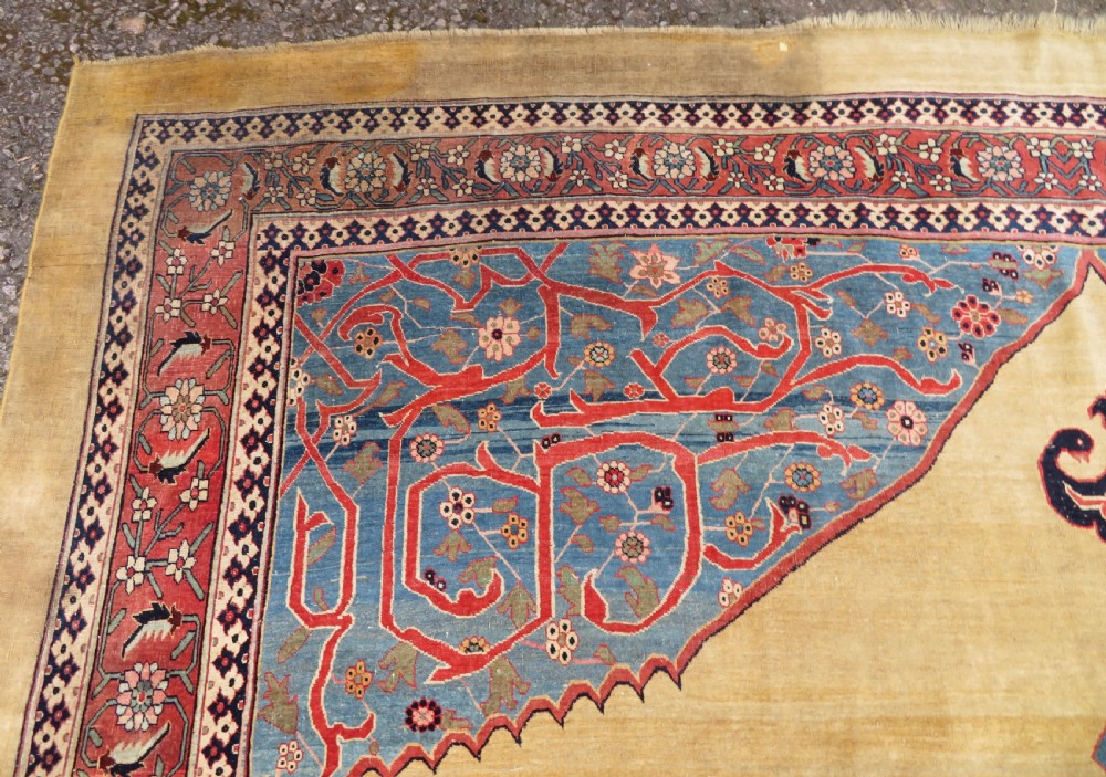A large hand-knotted antique Persian Bidjar carpet featuring a gold yellow field, central diamond medallion, blue corner spandrels, and a patterned red border. View XIV