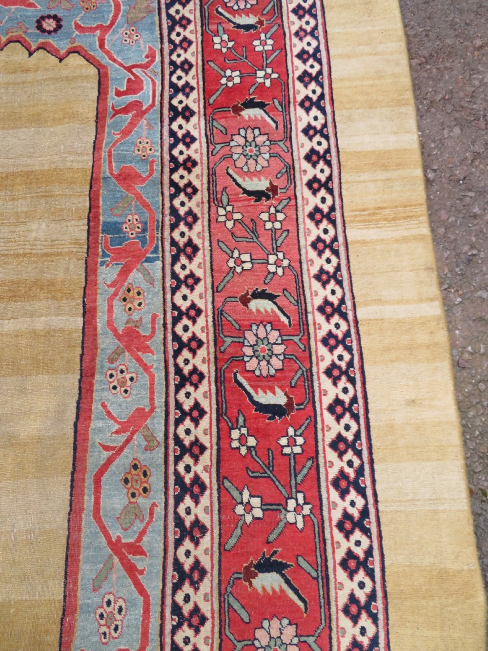 A large hand-knotted antique Persian Bidjar carpet featuring a gold yellow field, central diamond medallion, blue corner spandrels, and a patterned red border. View XVI