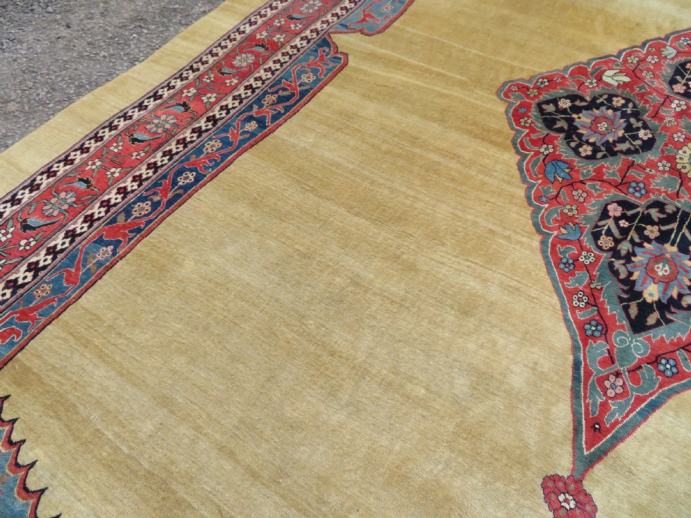 A large hand-knotted antique Persian Bidjar carpet featuring a gold yellow field, central diamond medallion, blue corner spandrels, and a patterned red border. View XIX