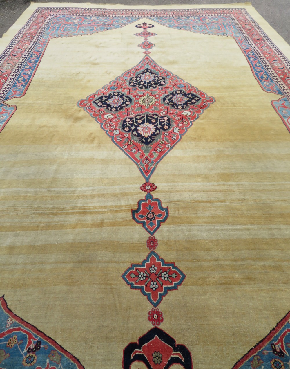 A large hand-knotted antique Persian Bidjar carpet featuring a gold yellow field, central diamond medallion, blue corner spandrels, and a patterned red border. View XXIII