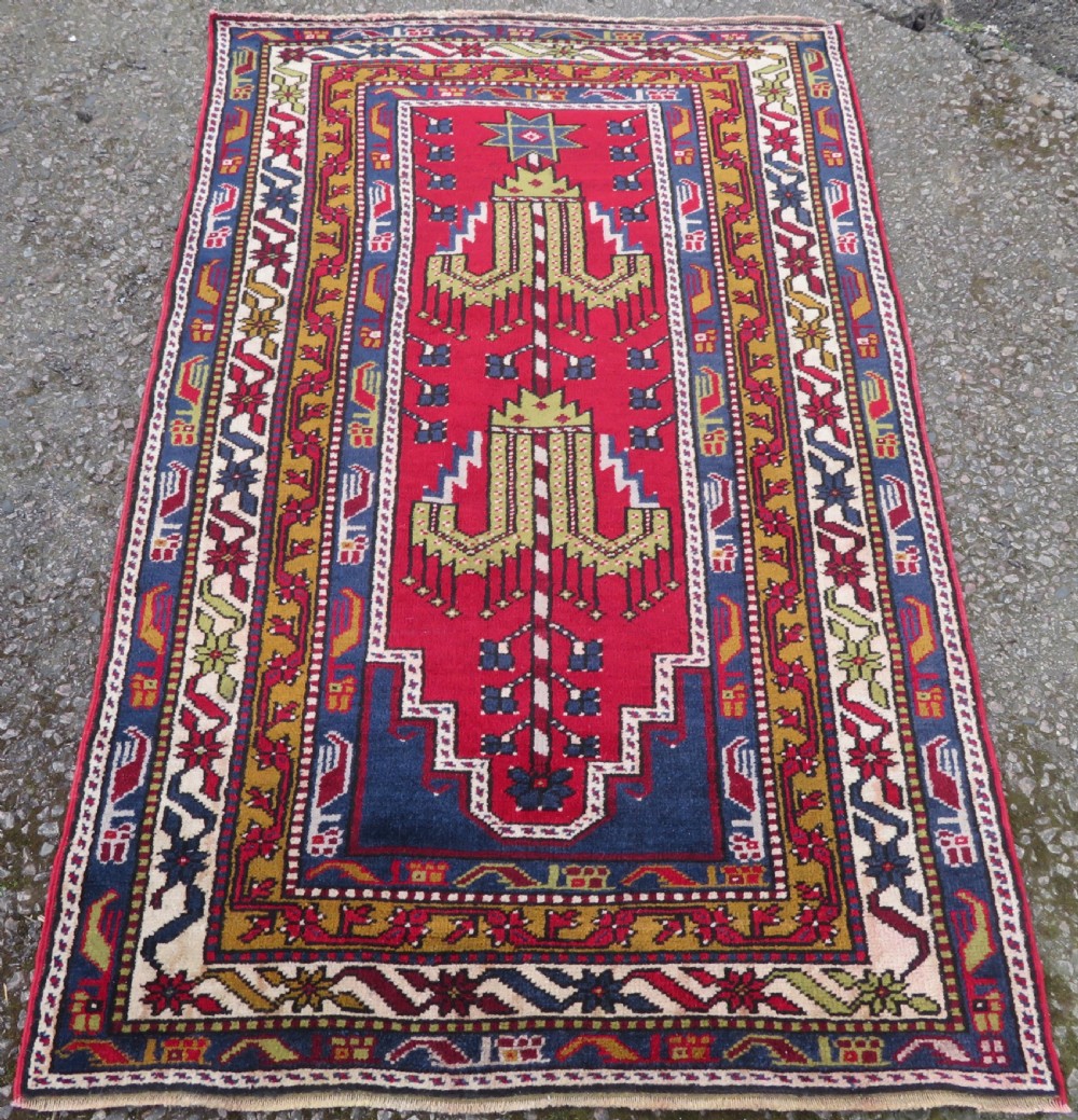 Hand-knotted Anatolian Kirsehir prayer rug featuring a red stepped niche central field with geometric floral motifs and a star, bordered by navy and mustard stripes. View II