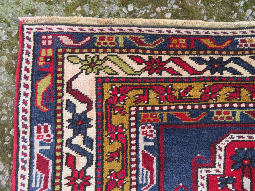 Hand-knotted Anatolian Kirsehir prayer rug featuring a red stepped niche central field with geometric floral motifs and a star, bordered by navy and mustard stripes. View VII