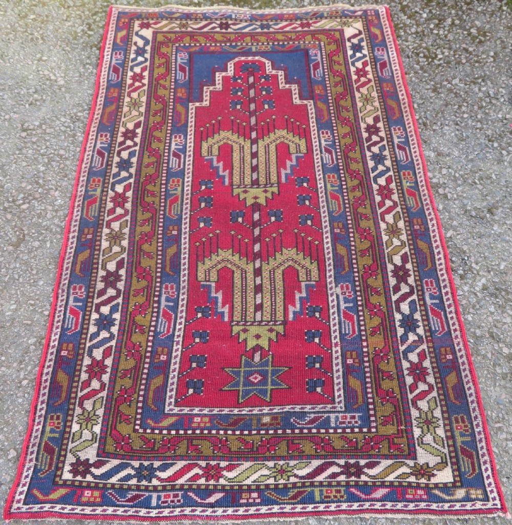 Hand-knotted Anatolian Kirsehir prayer rug featuring a red stepped niche central field with geometric floral motifs and a star, bordered by navy and mustard stripes. View VIII