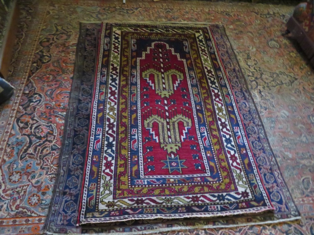Hand-knotted Anatolian Kirsehir prayer rug featuring a red stepped niche central field with geometric floral motifs and a star, bordered by navy and mustard stripes. View XI