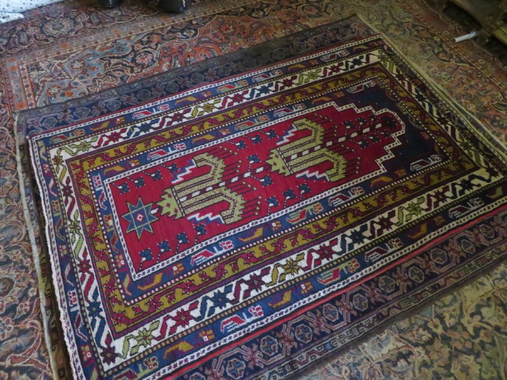 Hand-knotted Anatolian Kirsehir prayer rug featuring a red stepped niche central field with geometric floral motifs and a star, bordered by navy and mustard stripes. View XII