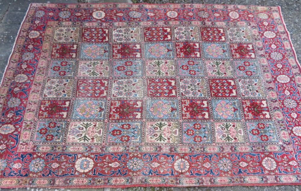 A hand-knotted Persian Qum rug featuring a grid tile pattern filled with floral and animal motifs inside a detailed red border. View III